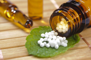 alternative medicine with homeopathic globules on leaf