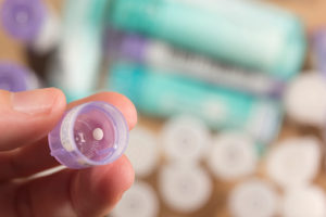 taking granules of homeopathic medication