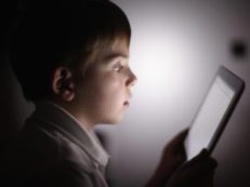 bambino al buio con smartphone